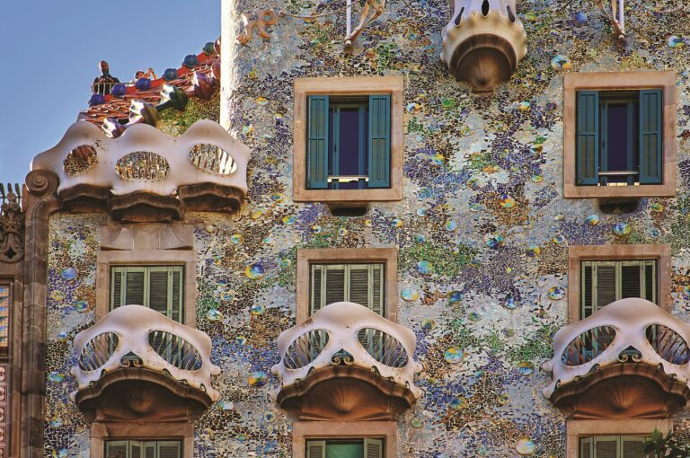 Casa Batlló se pyšní třpytivou fasádou vytvořenou z barevné mozaiky se zvláštními vyčnívajícími okny neobvyklého obloukovitého tvaru.